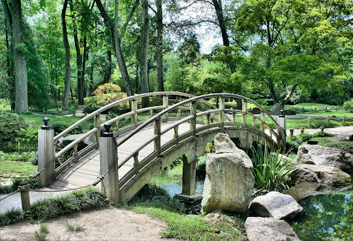 A lavish bridge park garden in front of a luxurious house