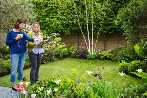 Two women inspecting the landscape design in a back yard by a landscaping company in west chester pa